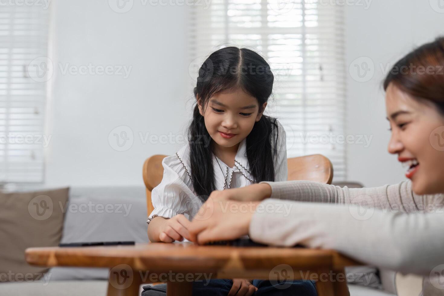 Mother-Daughter Bonding and Creative Play. A child draws with her mother, enjoying a peaceful afternoon at home. photo