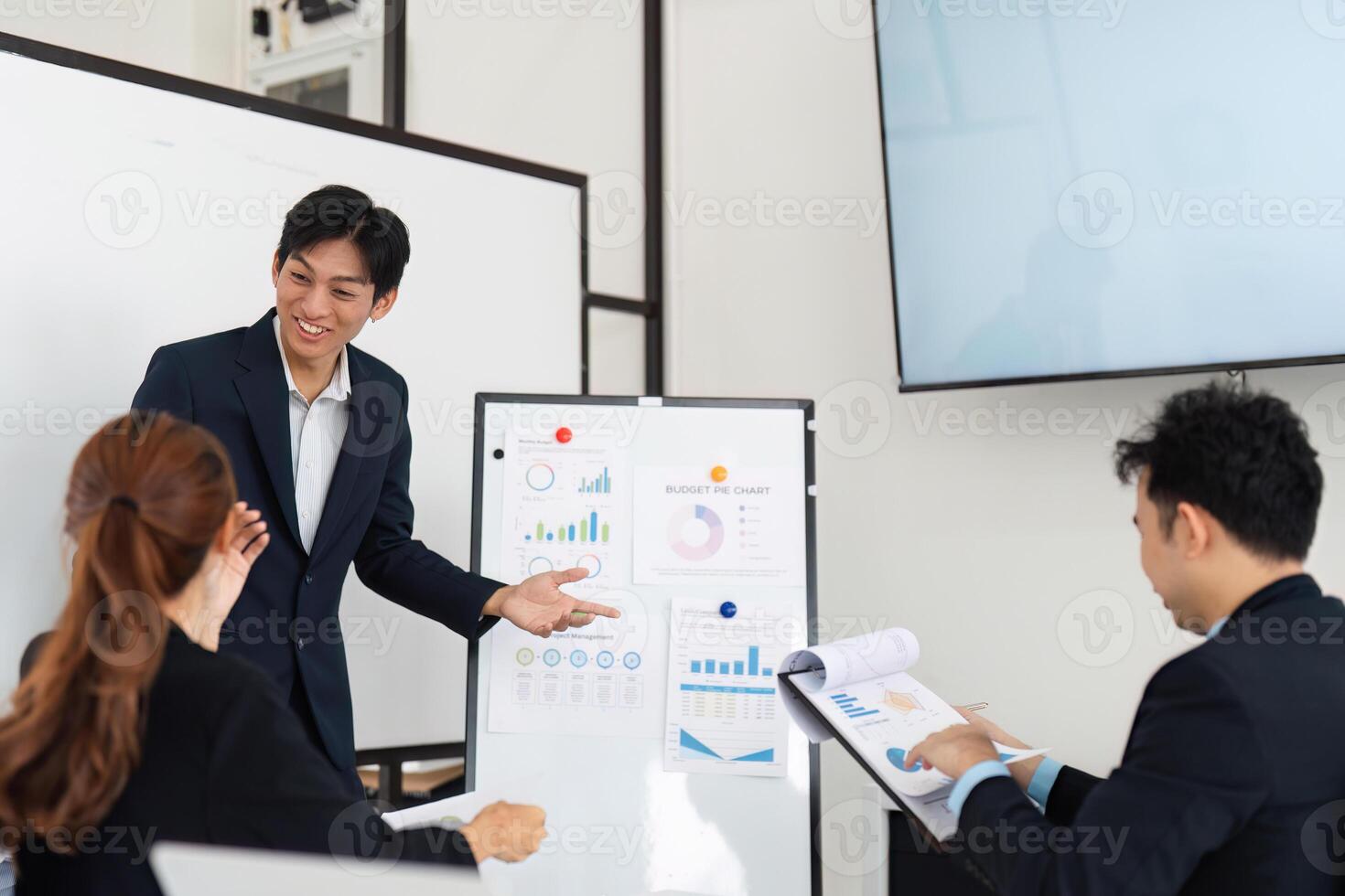 Team Meeting and Project Review. A young professional enthusiastically presenting visuals to engaged colleagues during a meeting. photo