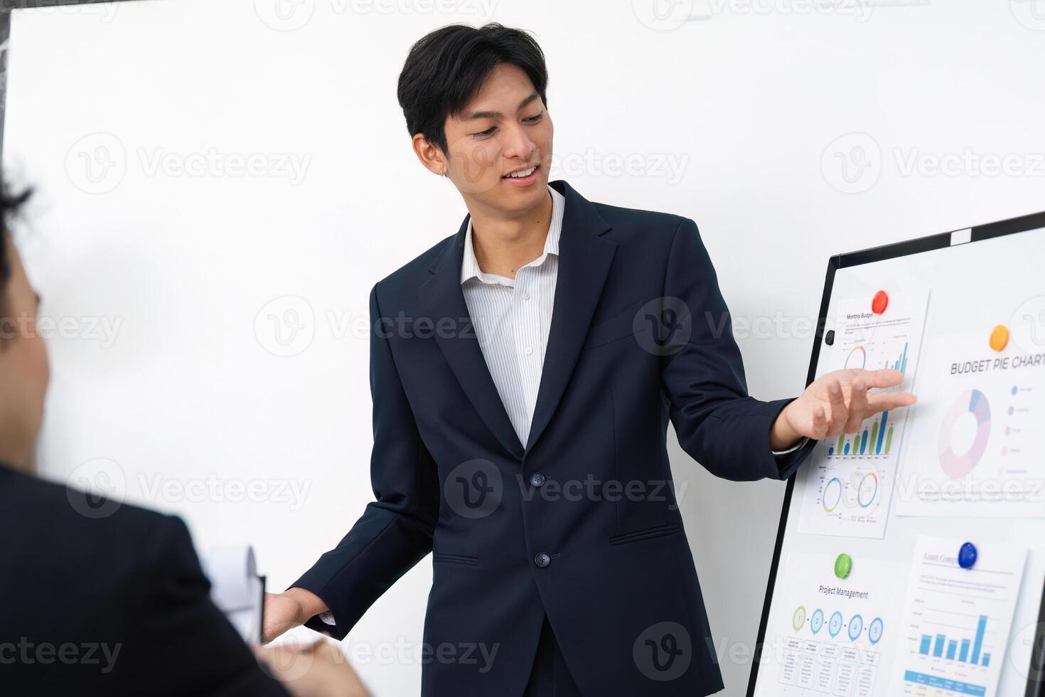 Business Presentation and Analytical Discussion. A young professional presenting financial data to a team. photo