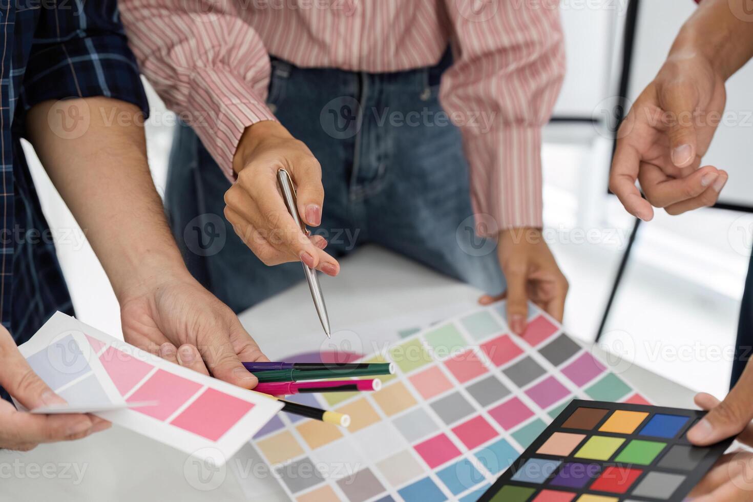 Team Collaboration and Color Selection. A group collaborates on selecting the perfect color palettes for their project. photo