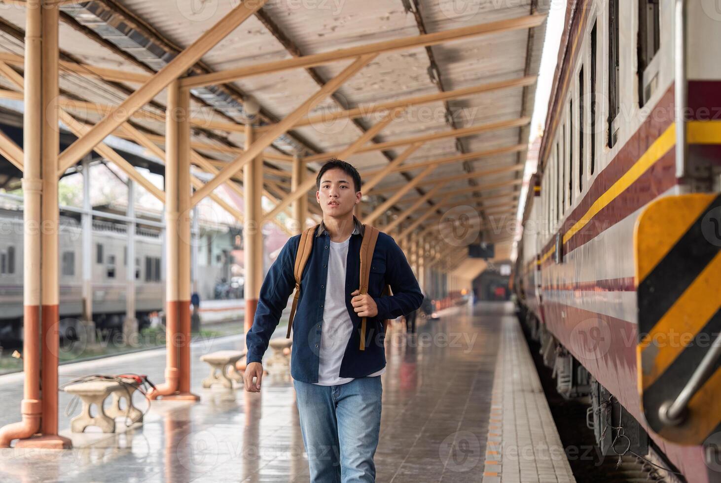 Eager Traveler at the Train Station. A young man walking with purpose towards his destination. photo