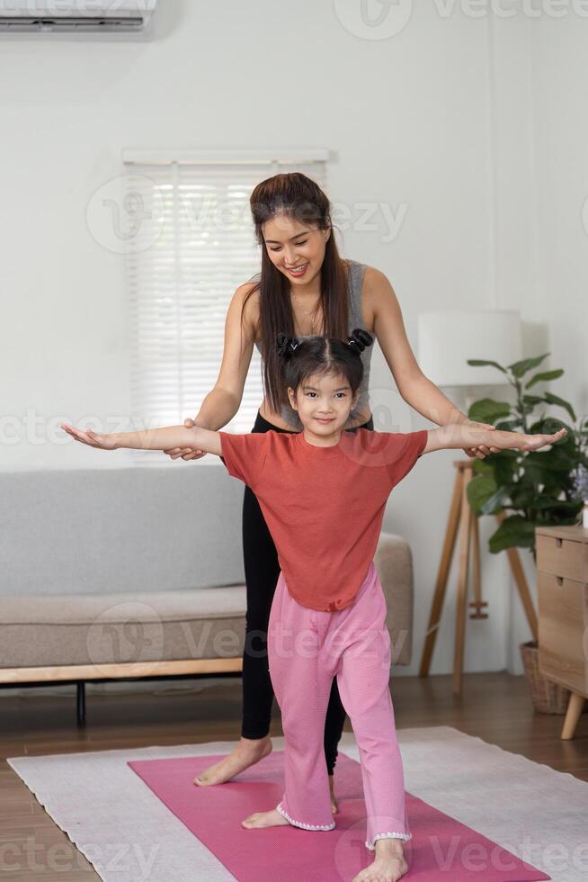 Strength and Connection. A mother guides her daughter through an encouraging exercise session. photo