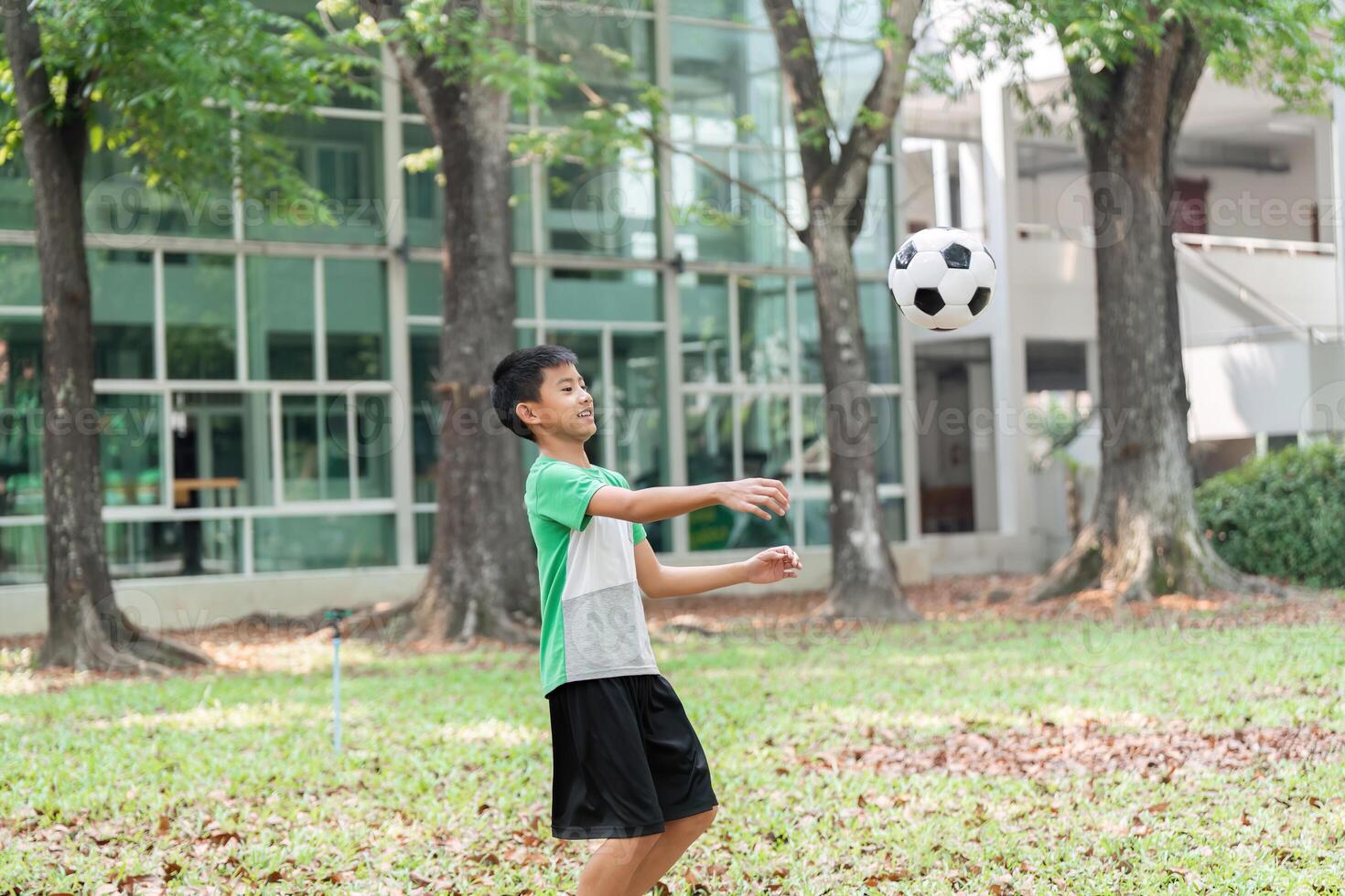 Soccer Skills and Focus. A boy practices his soccer skills by catching a ball in the park. photo
