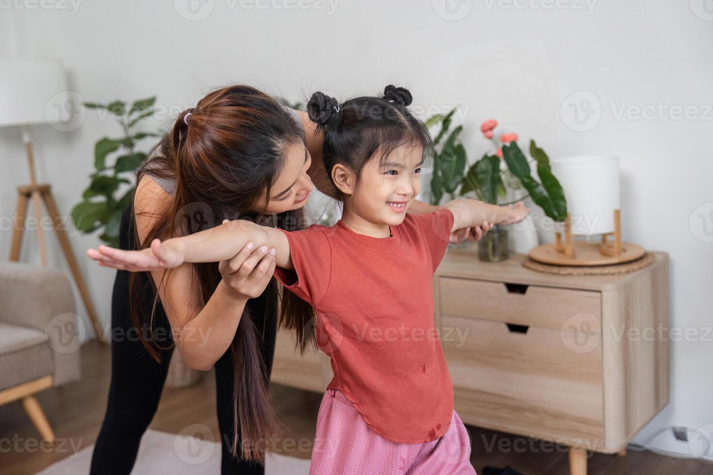 Exercise and Parent-Child Bonding. A mother teaching her daughter how to stretch in a playful and engaging way. photo