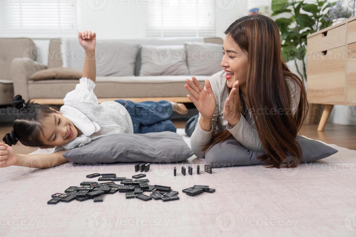 Family Bonding and Playtime. A mother and daughter share a joyful moment while playing a game on the floor, strengthening their connection through laughter. photo