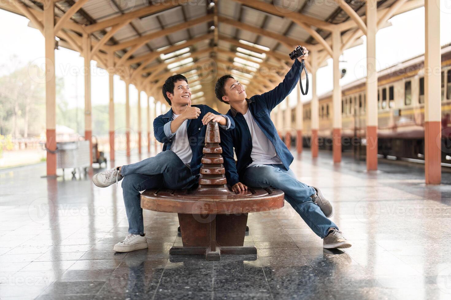 Travel and Exploration. Friends capturing joyful moments at a train station with their camera. photo