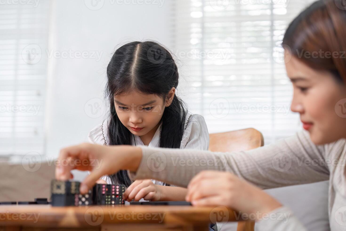 Focused Play and Family Moments. A young girl and her mother engage in a creative game activity, deepening their bond. photo
