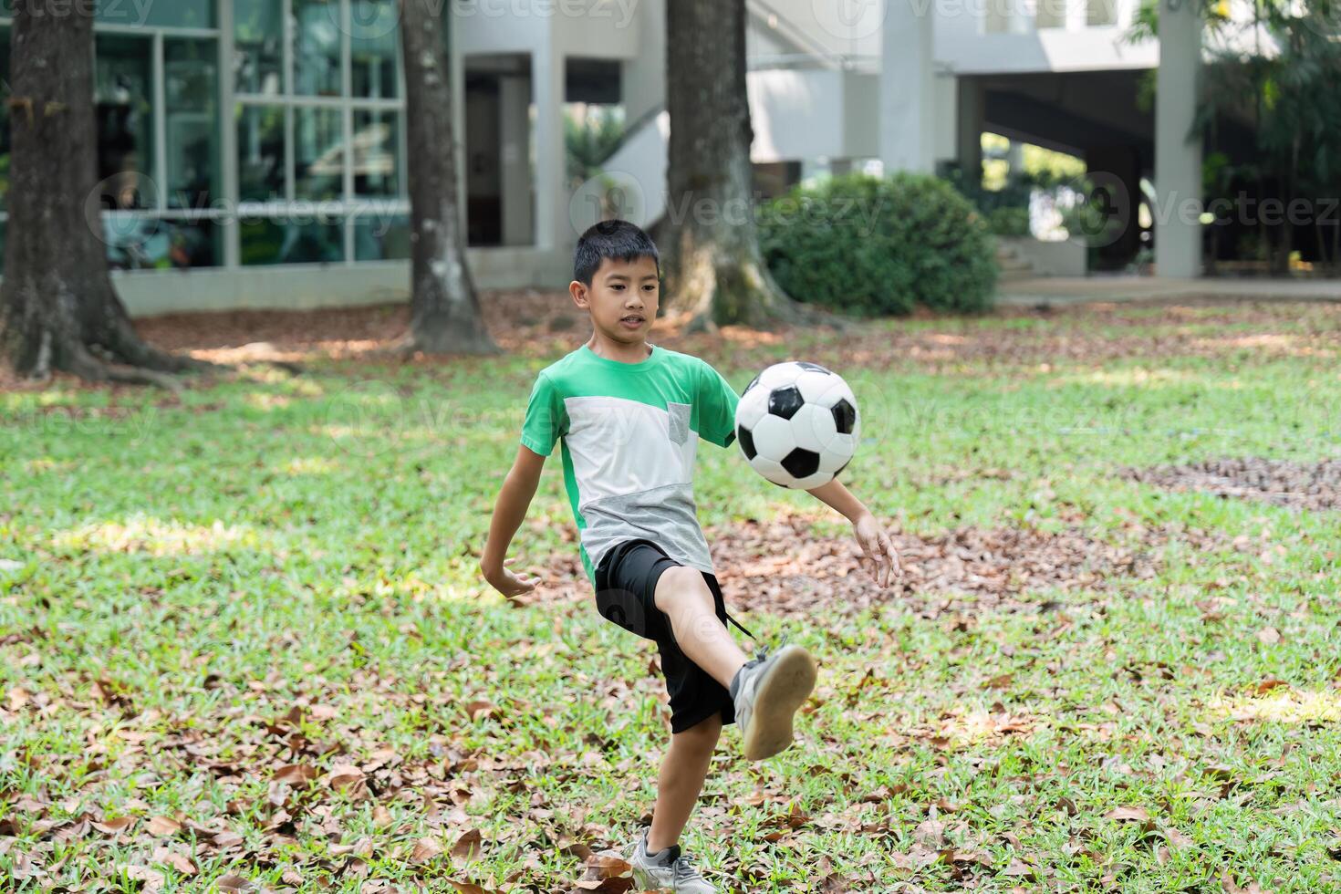 Skill Development and Outdoor Fun. A boy practicing soccer skills with a woman in a park setting. photo