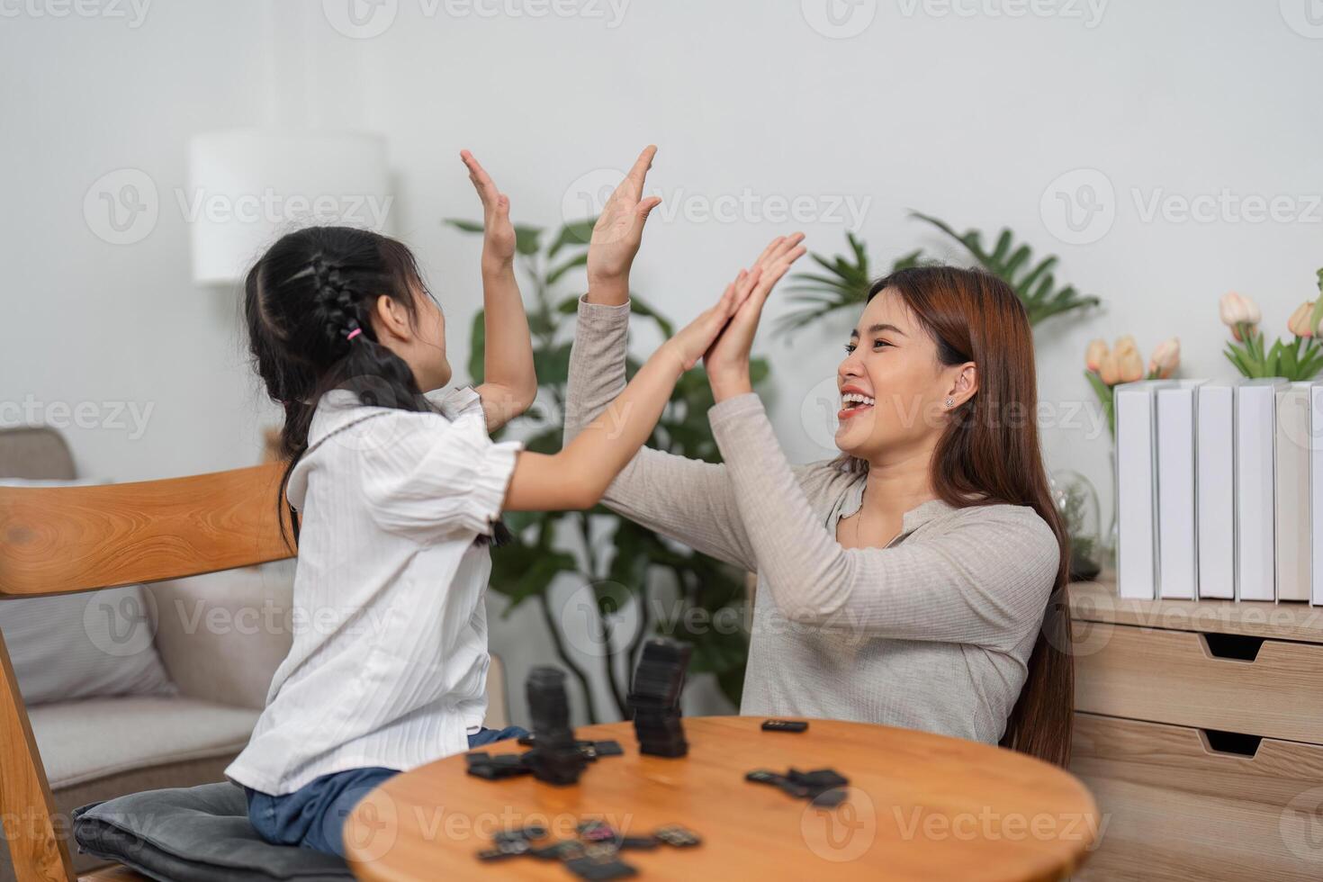 Joyful Moments and Family Play. A vibrant game of dominoes showcases a mother's playful connection with her daughter. photo