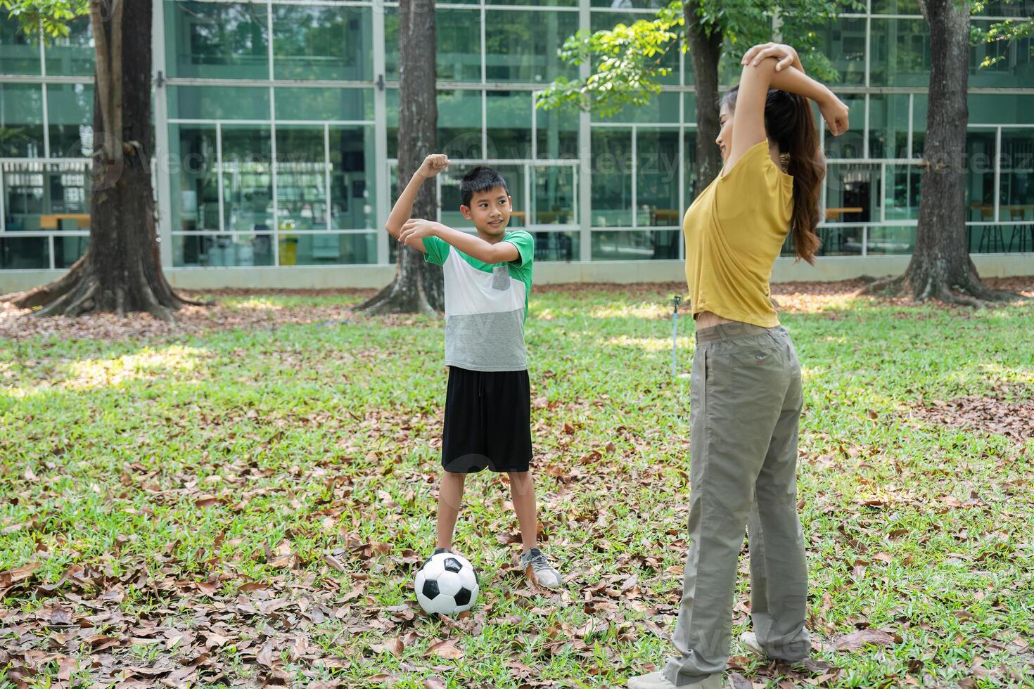 Fitness and Family Time. A mother and her son stretching before a game, promoting health and bonding. photo