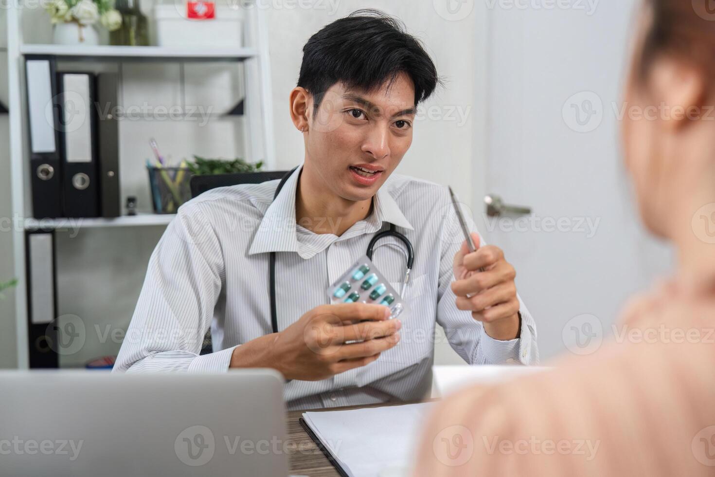 Patient Education and Medication Overview. Doctor elaborating on medication while showing a pill pack. photo