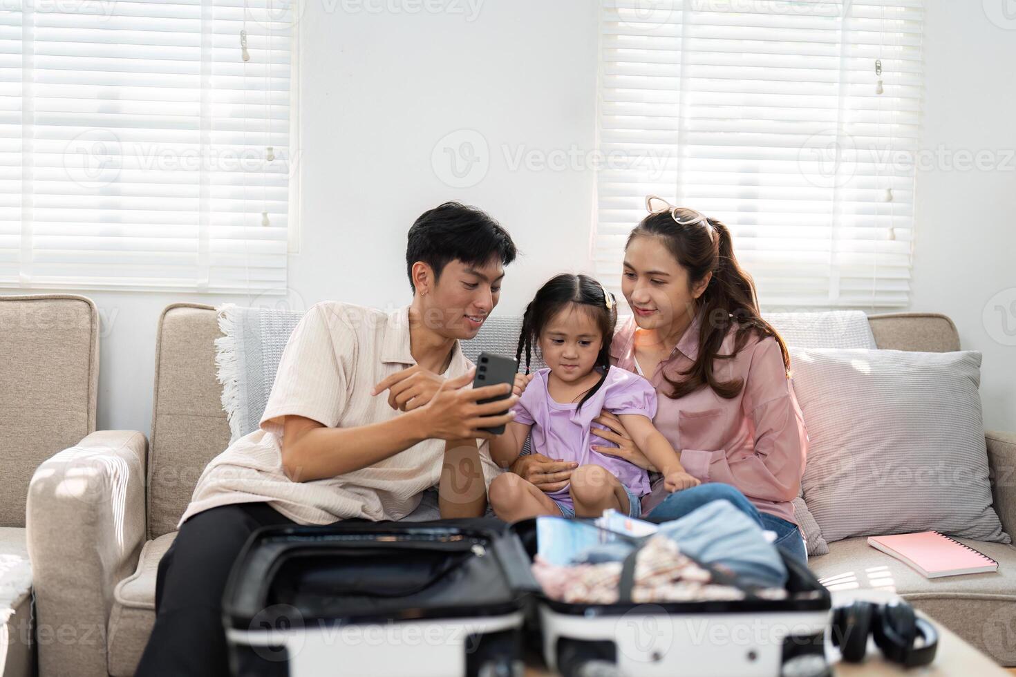 Family Preparation and Packing. Parents assist their daughter in organizing a suitcase, preparing for an upcoming family trip. photo