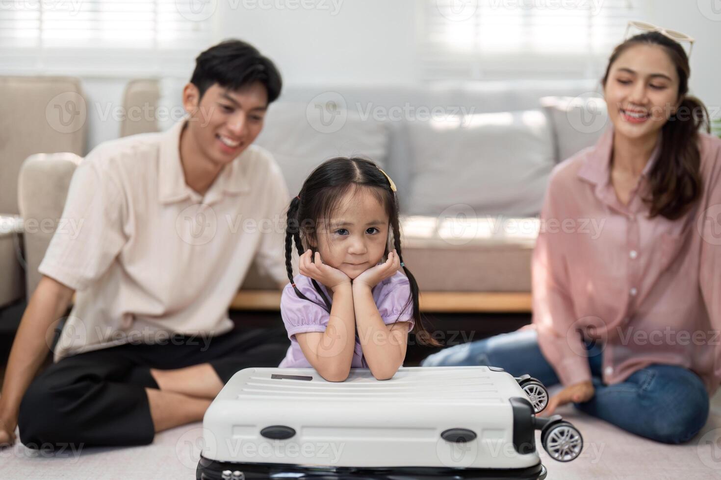 Joyful Family Activities and Packing Fun. A young girl makes packing lively while sitting on a suitcase, capturing family essence. photo