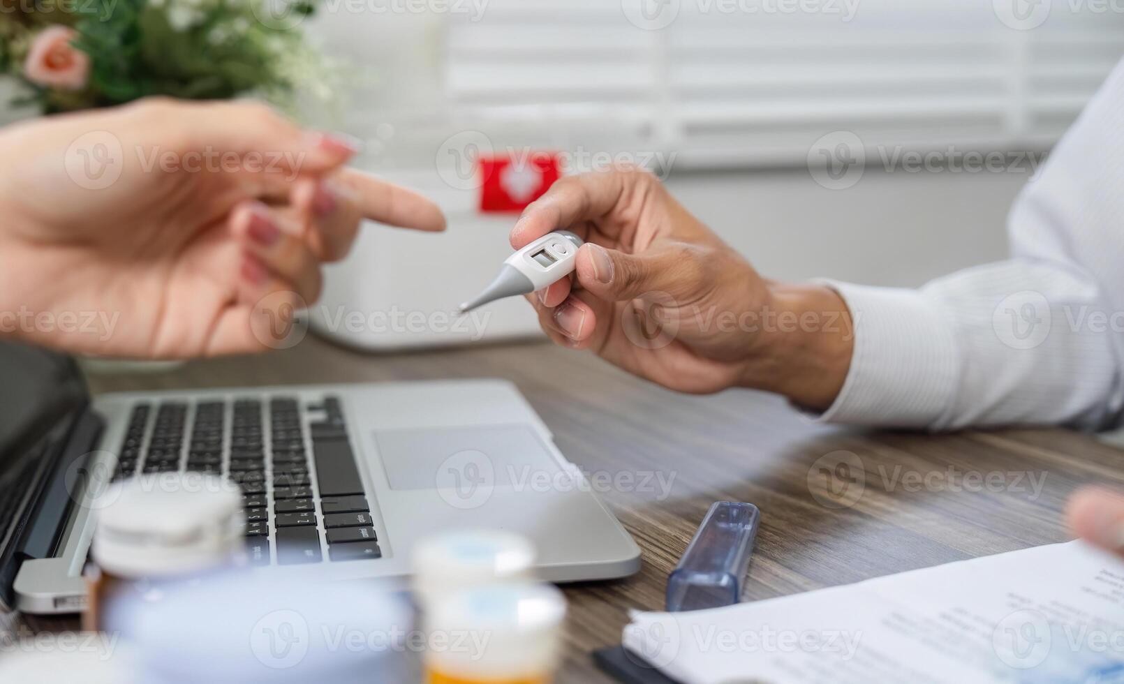 Health Monitoring Discussion. A doctor interacts with a patient about health metrics using a thermometer. photo