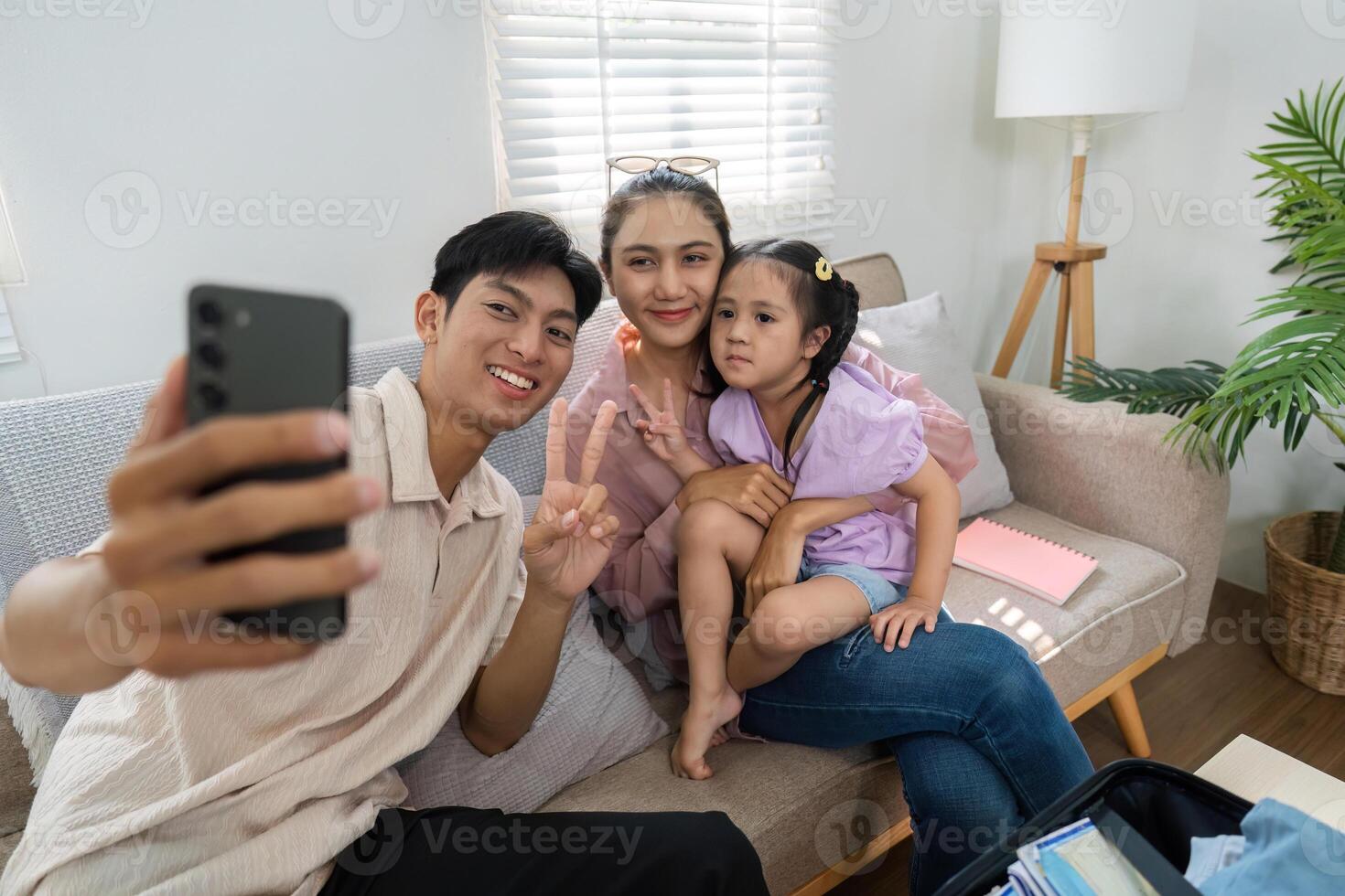 Family Memories and Selfies. A family capturing joyful moments together in their living room. photo