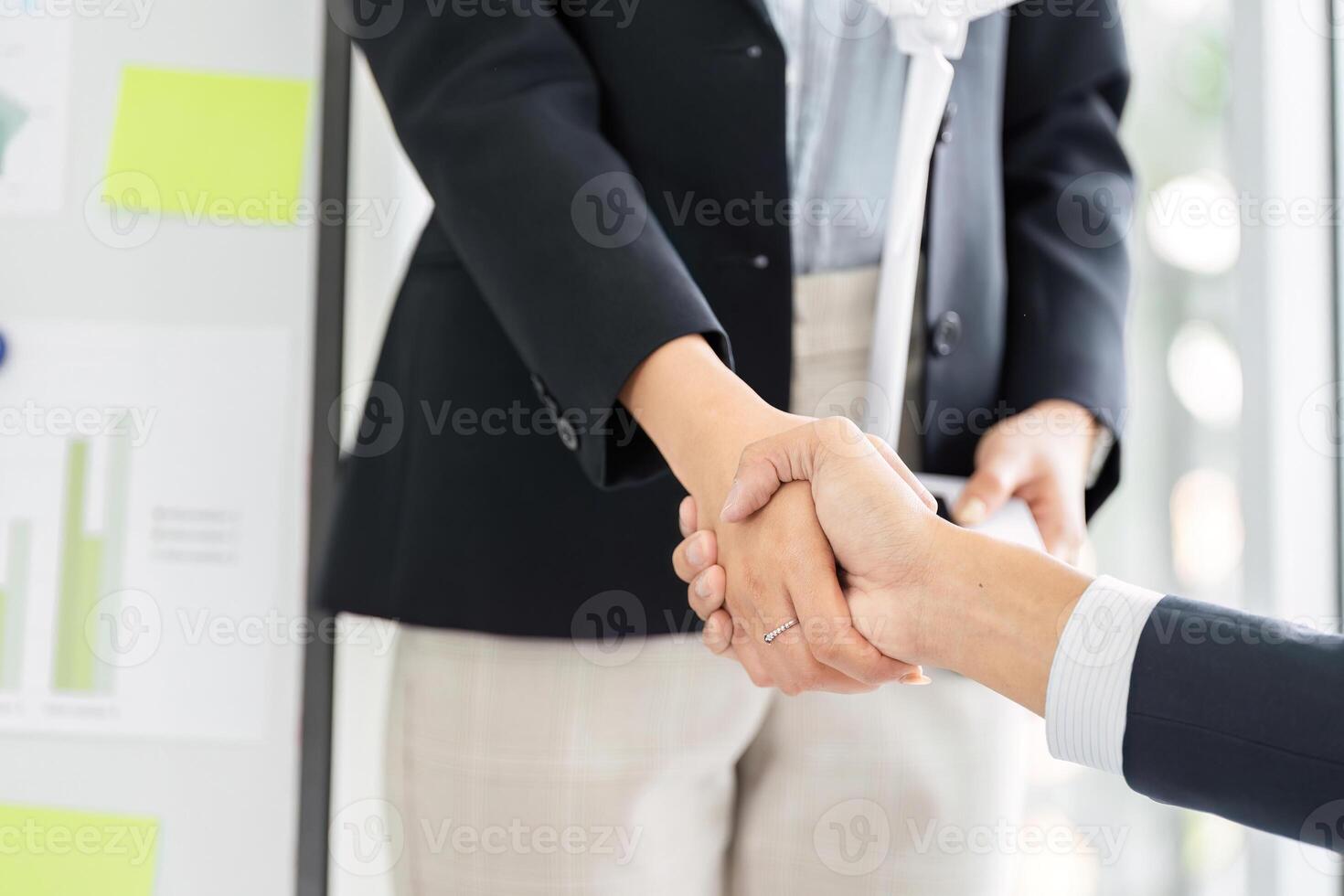 Business Collaboration and Sustainability. Two professionals engage in a handshake, solidifying their partnership in an eco-friendly project. photo