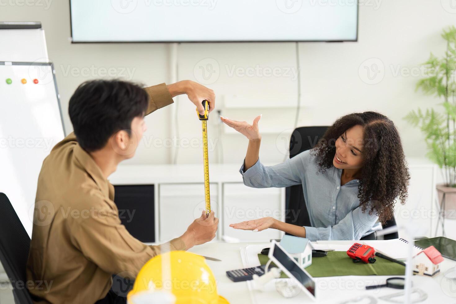 Sustainable Development and Collaborative Design. Two colleagues engaging in a brainstorming session over architectural models. photo
