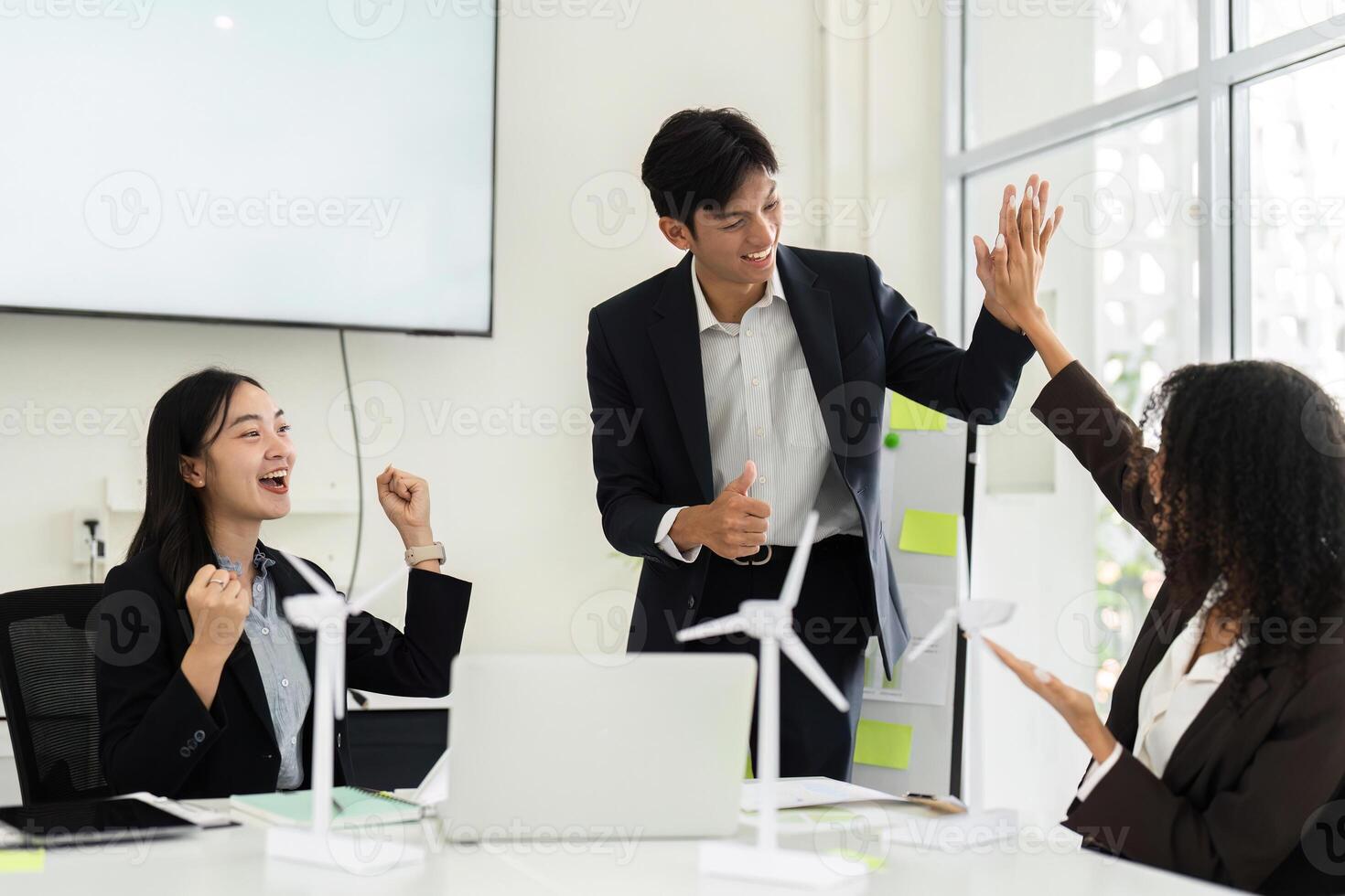 Celebrating ESG Success and Team Spirit. Colleagues high-fiving after achieving a milestone in sustainable initiatives. photo