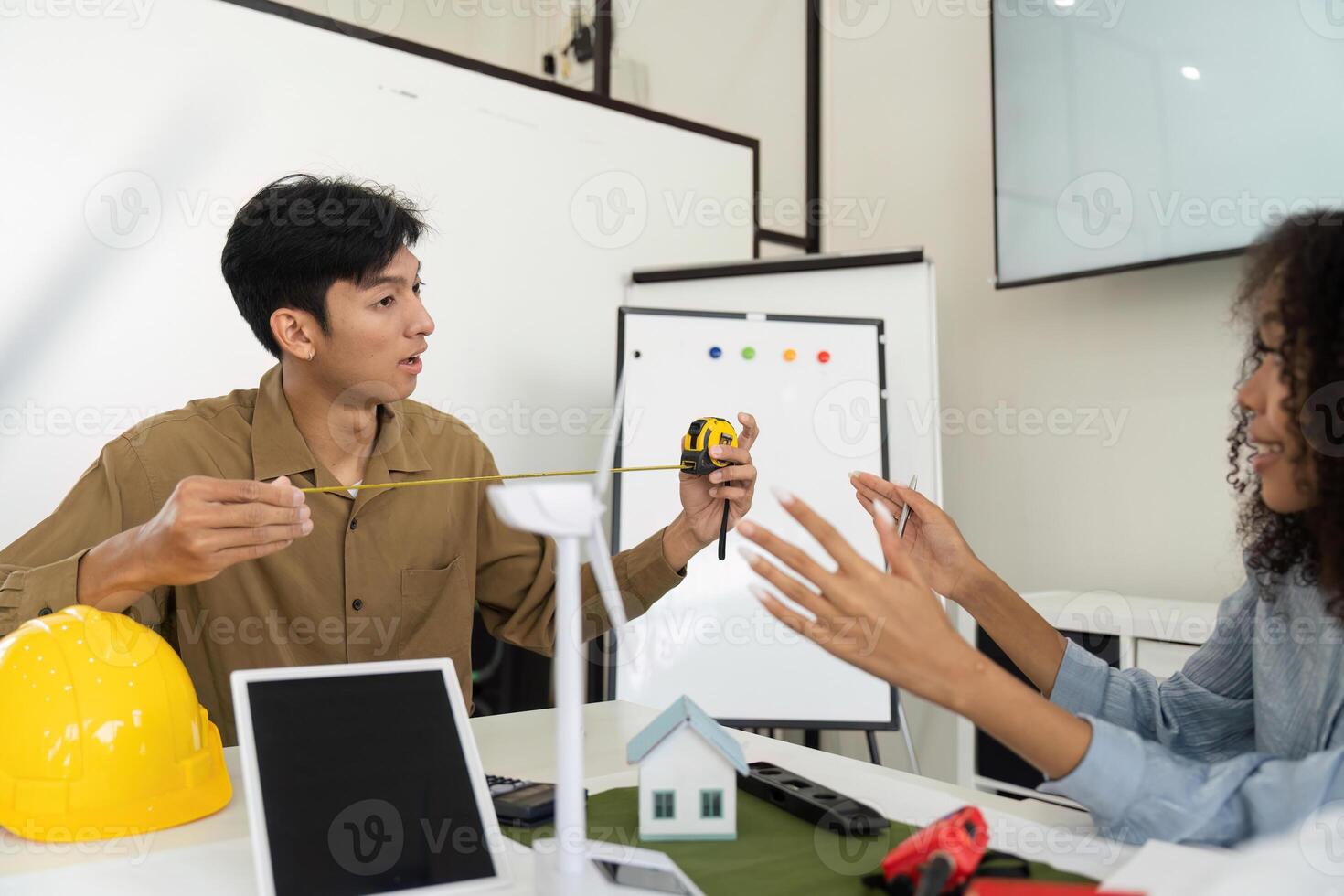 Sustainable Design and Project Planning. Team measuring dimensions for an eco-friendly building project in a modern office. photo