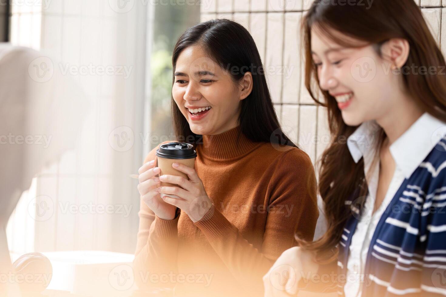 Coffee Break and Socializing. A joyful student enjoying a coffee break with friends in a bright cafe. photo