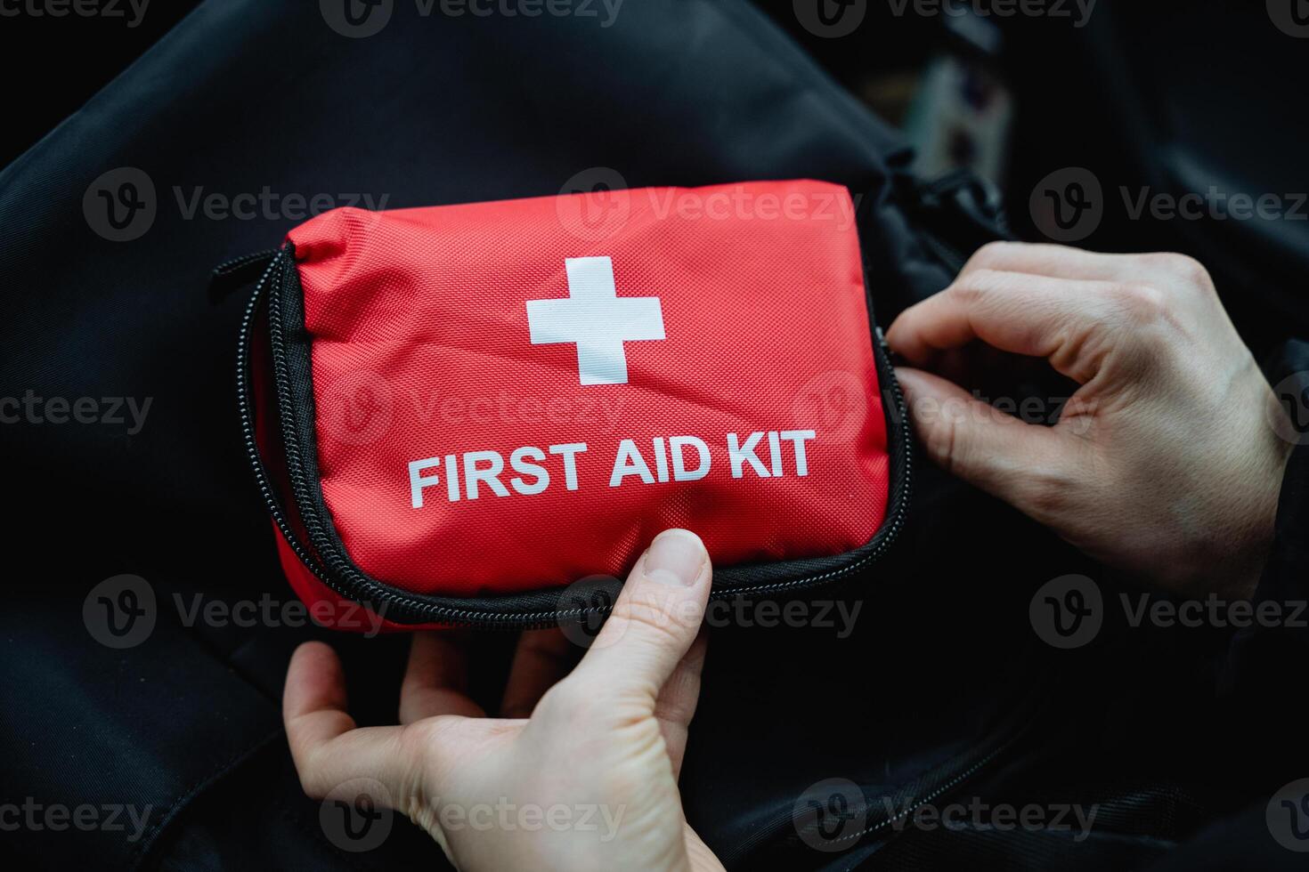 A person firmly grips a fully stocked first aid kit, prepared for any potential emergencies that may arise. This kit is essential for providing immediate medical assistance when necessary photo