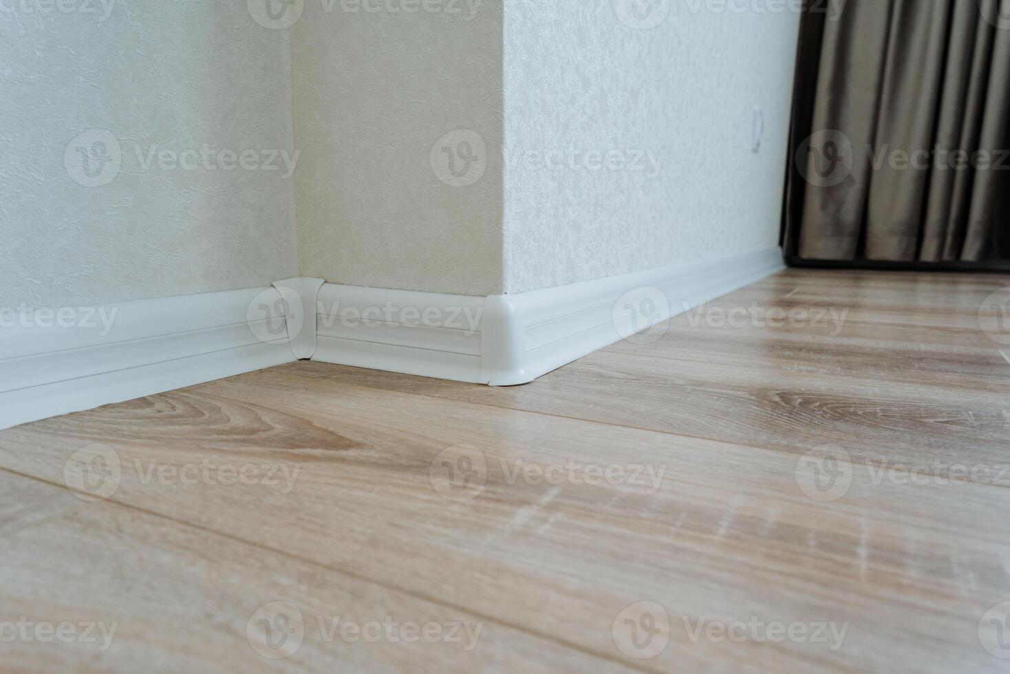 In a cozy room corner, a stunning wooden floor with beautiful, elegant white trim beautifully enhances the overall aesthetics and charm of the entire living space and atmosphere photo