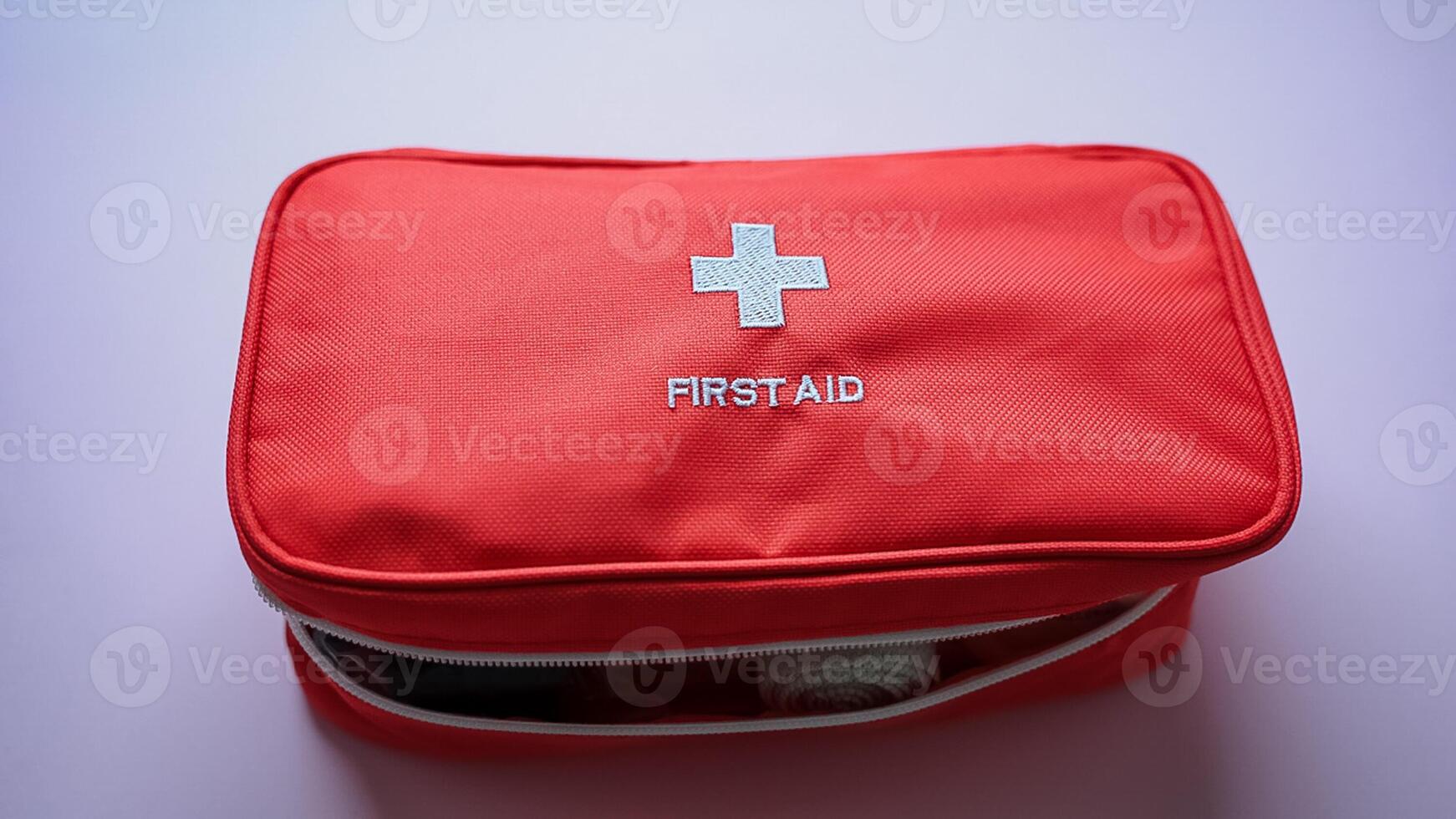 A bright red first aid kit with a white cross symbolizes its vital role in health emergencies, providing essential medical assistance when needed, showcasing its lifesaving importance photo
