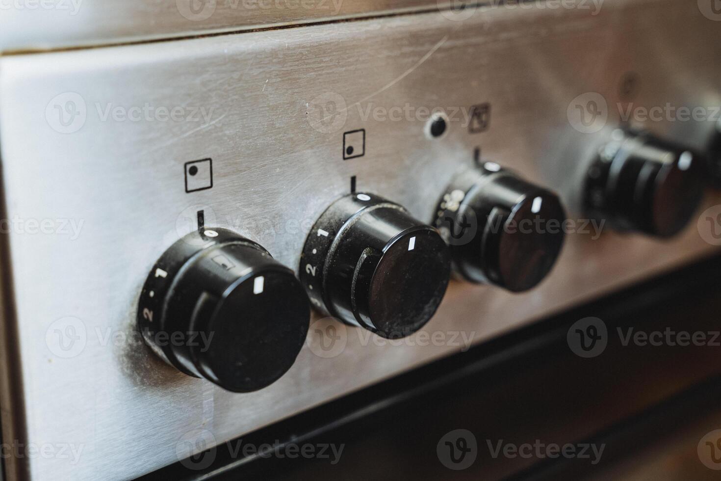 This detailed closeup shows a contemporary stove with striking black knobs, highlighting its unique design, aesthetic appeal, and excellent functionality in the kitchen photo