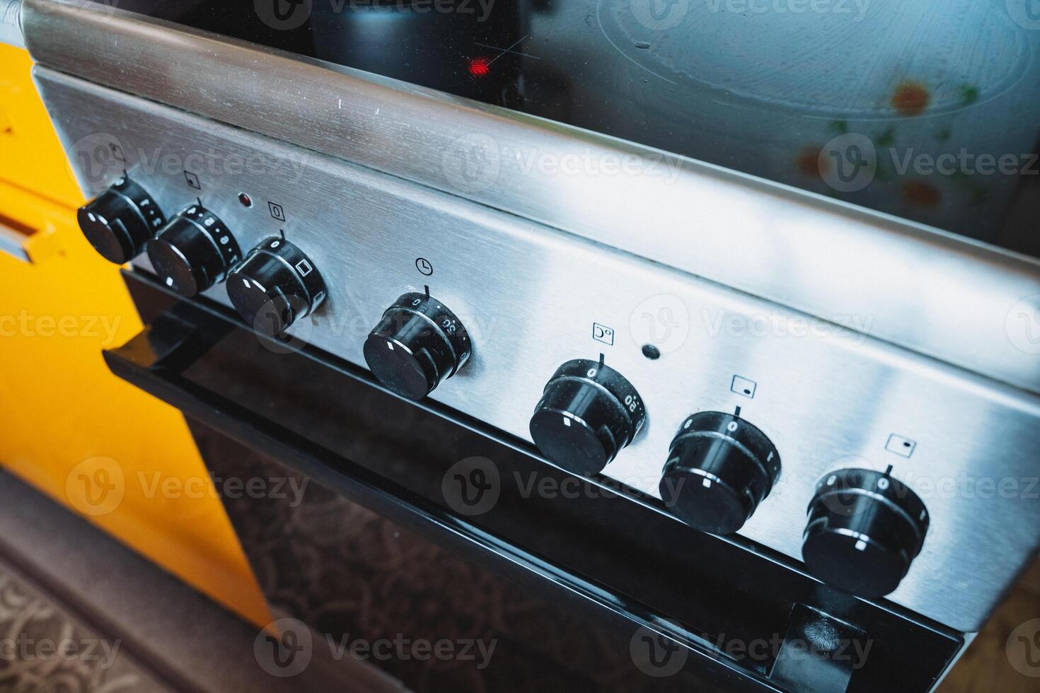 This image features a closeup view of a stove, with a vibrant yellow cabinet visible in the background, enhancing the kitchens overall look and feel, making it more inviting photo