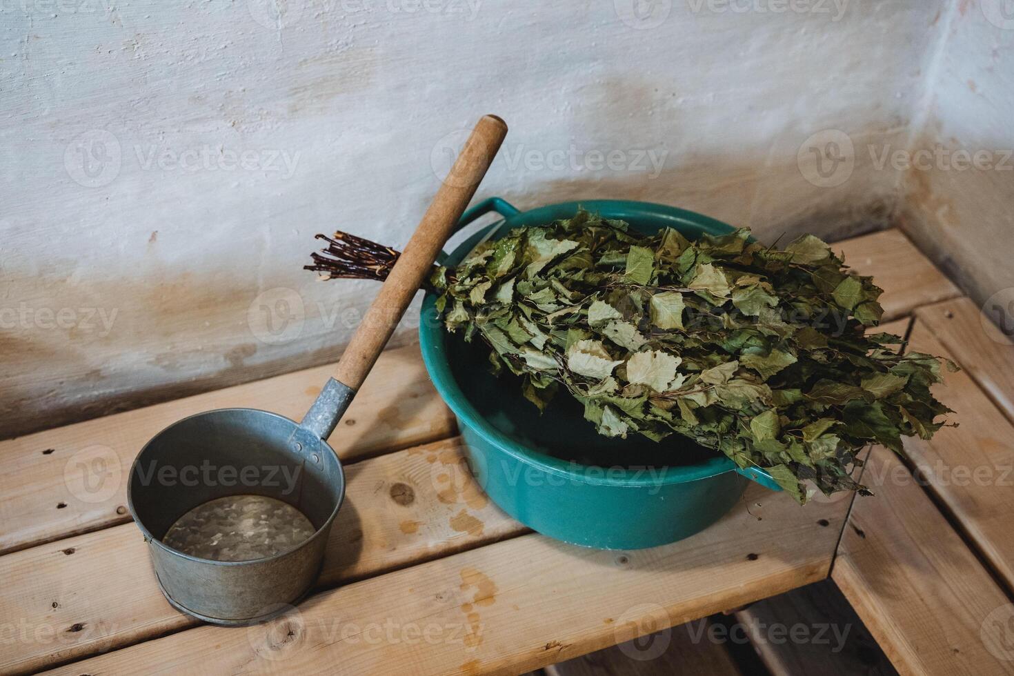 A bright green bucket, brimming with sparkling water and vibrant leaves, is placed gracefully on a sturdy wooden bench, nestled in a picturesque outdoor setting that exhibits natural beauty photo
