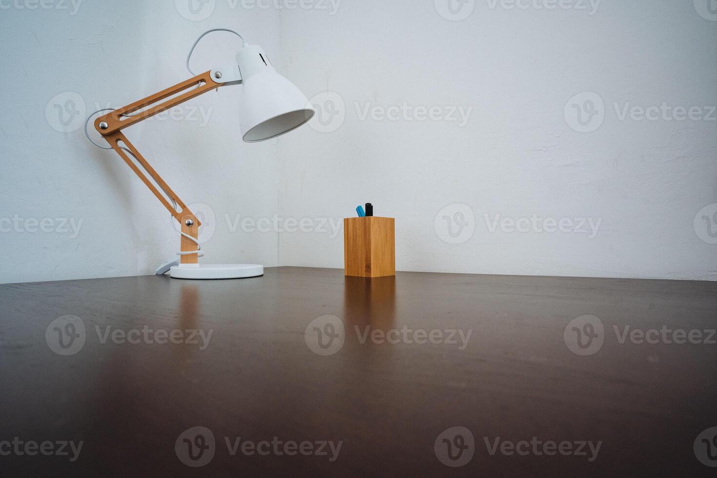 A tidy desk with a soft lamp and organized pen holder enhances functionality and aesthetics, making the workspace more inviting, comfortable, and conducive to productivity and creativity photo