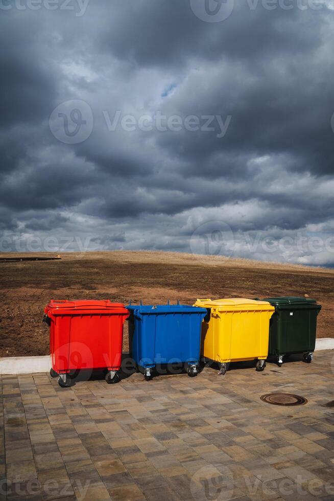 Four uniquely designed, vibrantly colored trash cans arranged in a line create an organized waste management system, encouraging responsible and efficient garbage disposal photo