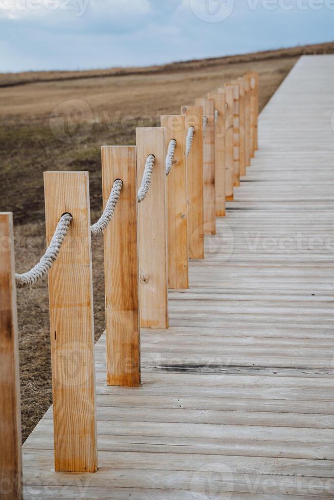 Wooden posts are aligned in a straight row, with strong ropes tied to each, creating a clear boundary that enhances safety and organization, making the area more accessible and efficient photo