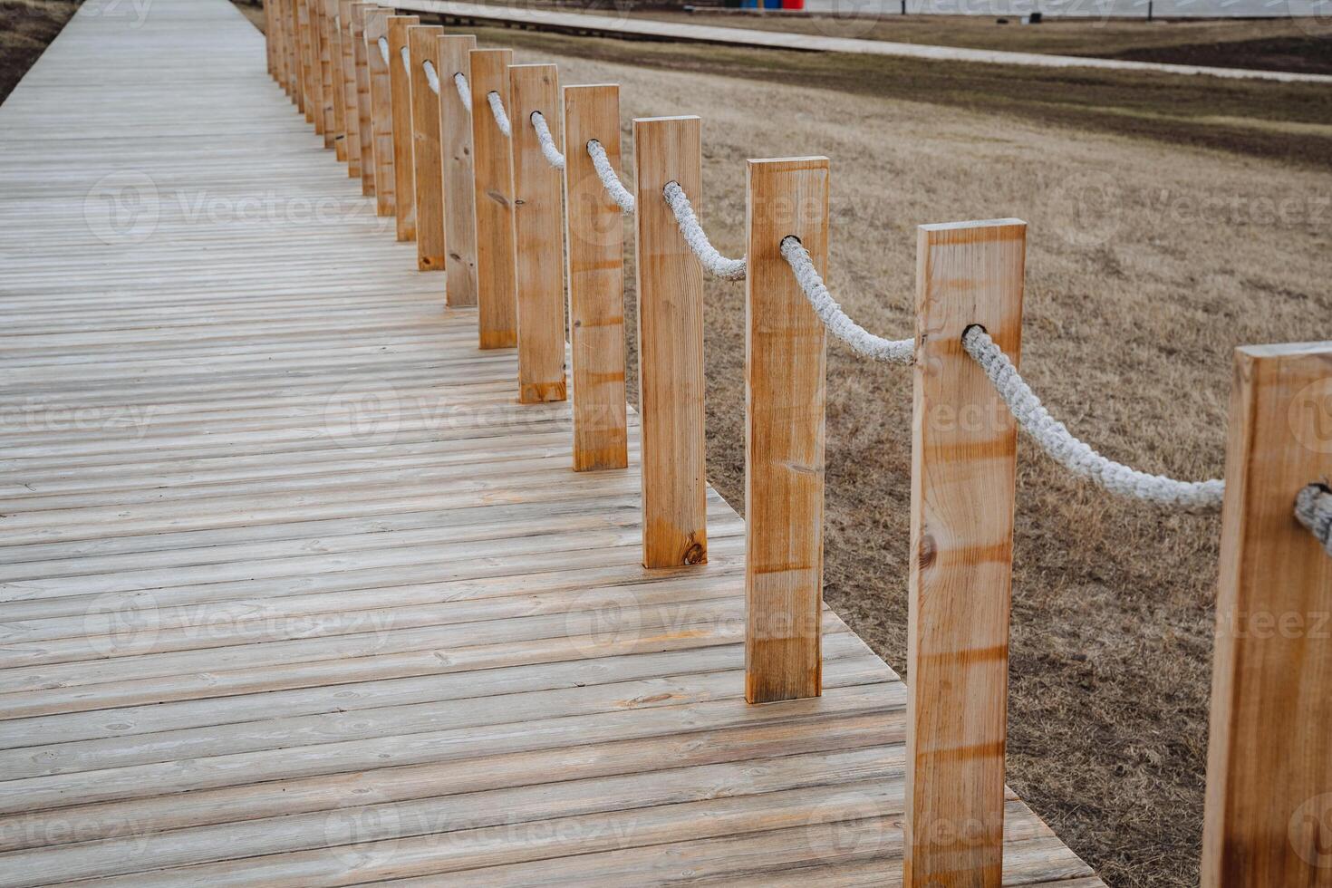 There is a wooden walkway featuring a wellconstructed rope fence situated alongside it, providing both safety and style for those walking along this beautiful path in nature photo