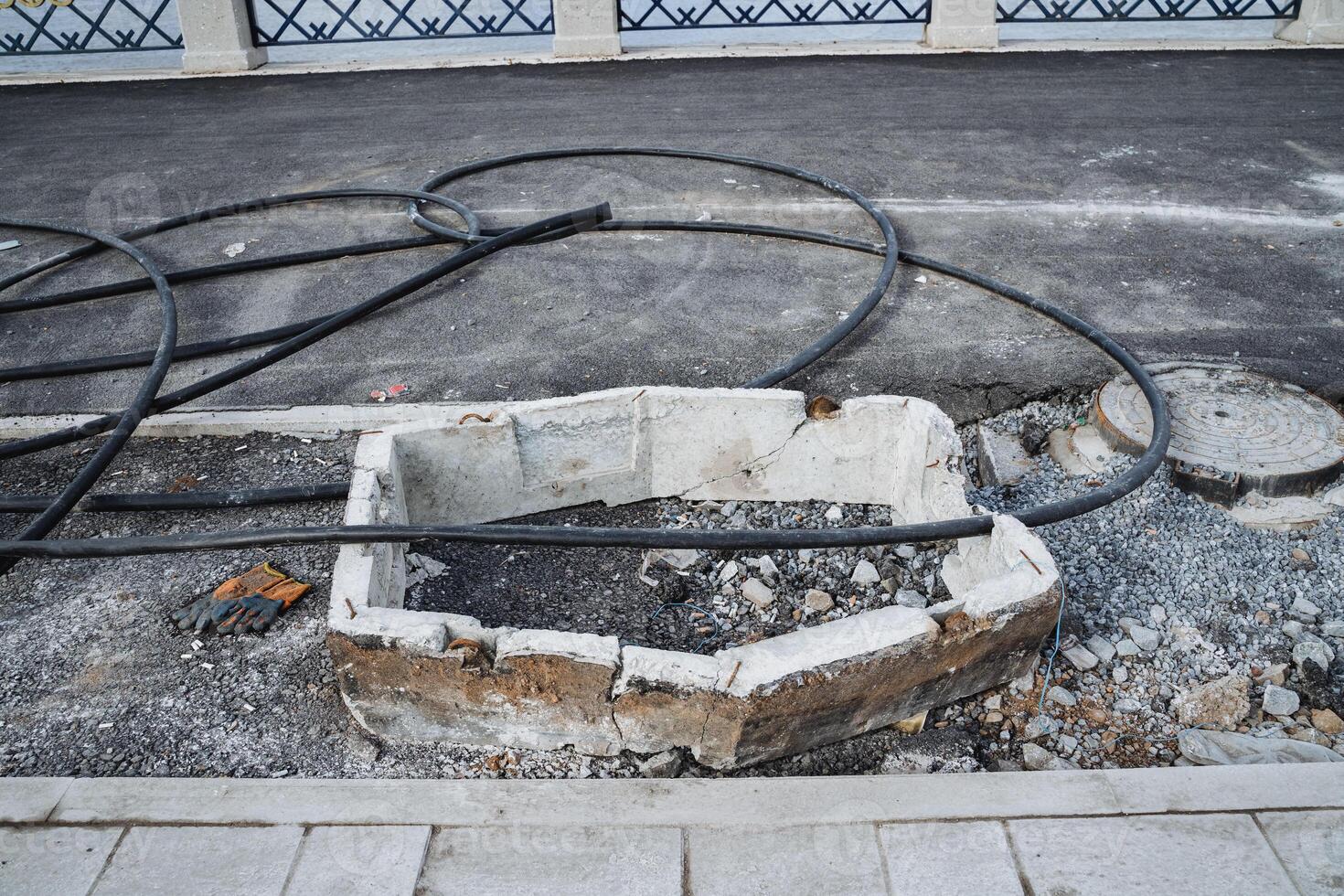 A unique and distinct hole in the ground can be seen, with numerous wires extending outwards in a variety of directions, suggesting an entangled and complex setup or structure photo