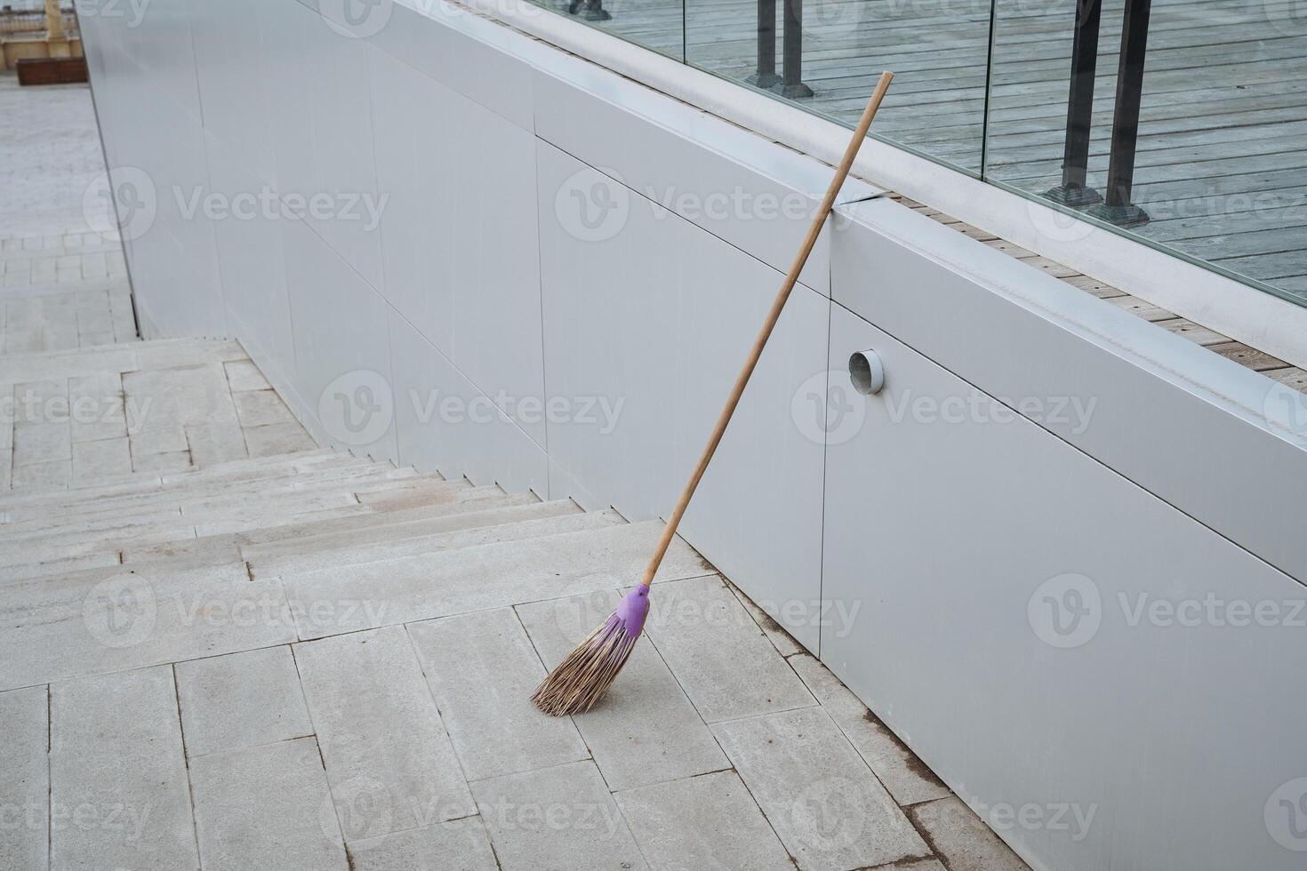 On a tiled floor, there is a broom that features a striking purple handle, making it a colorful addition to the household cleaning supplies that can be found in any home photo