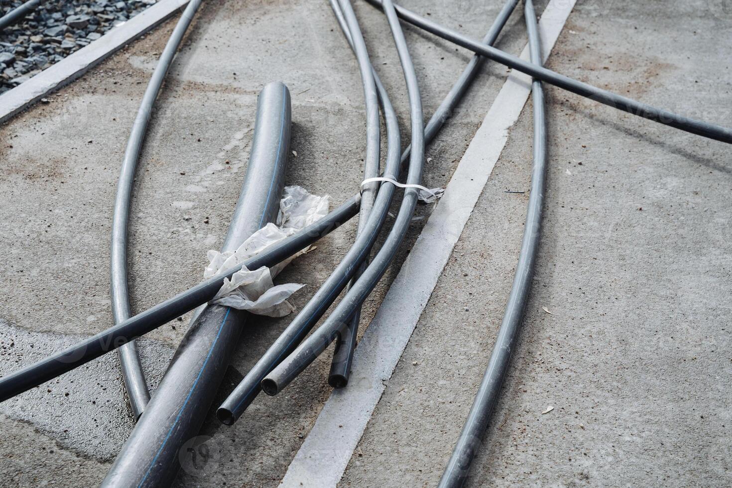 A collection of electrical wires is lying scattered across the ground in various positions and directions, creating a chaotic scene that needs careful handling and organization photo