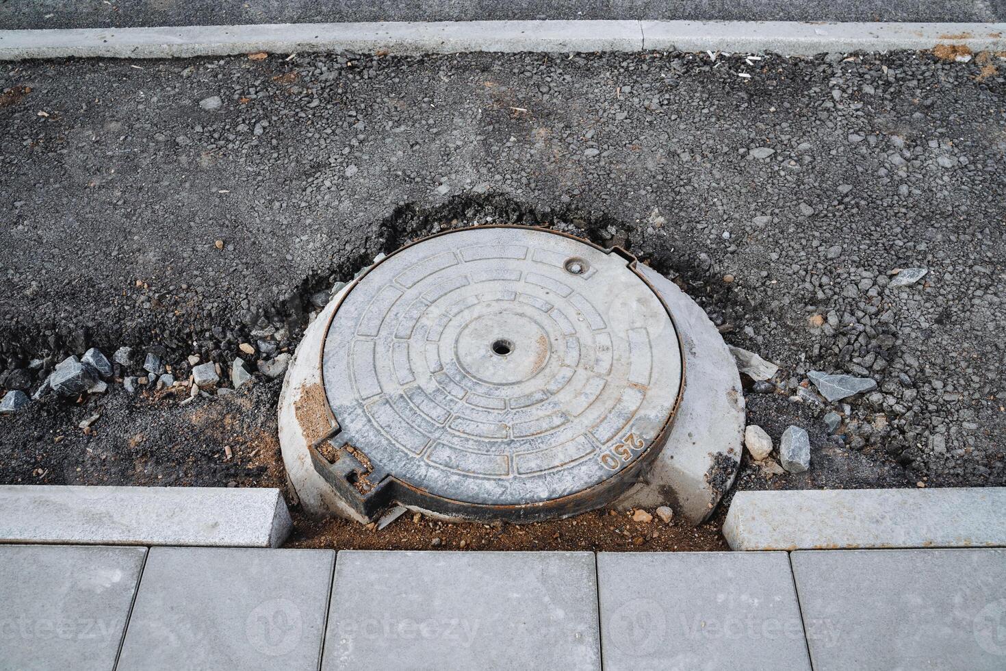 A manhole cover is sitting on the side of the road photo