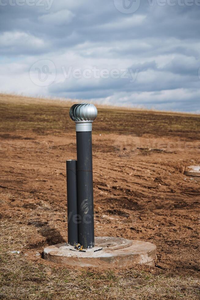 A long pipe is positioned right in the center of a sprawling dirt field, surrounded by barren land, just sitting there quietly without any movement or activity around it photo