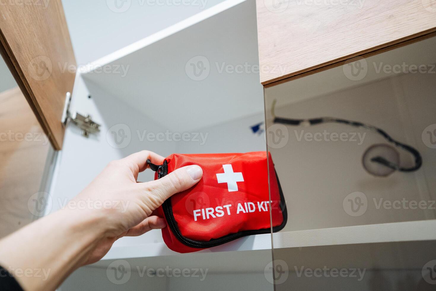 A person confidently holds a bright red first aid kit, ready to assist anyone in need of medical attention during an emergency, showcasing assurance and preparedness to help photo