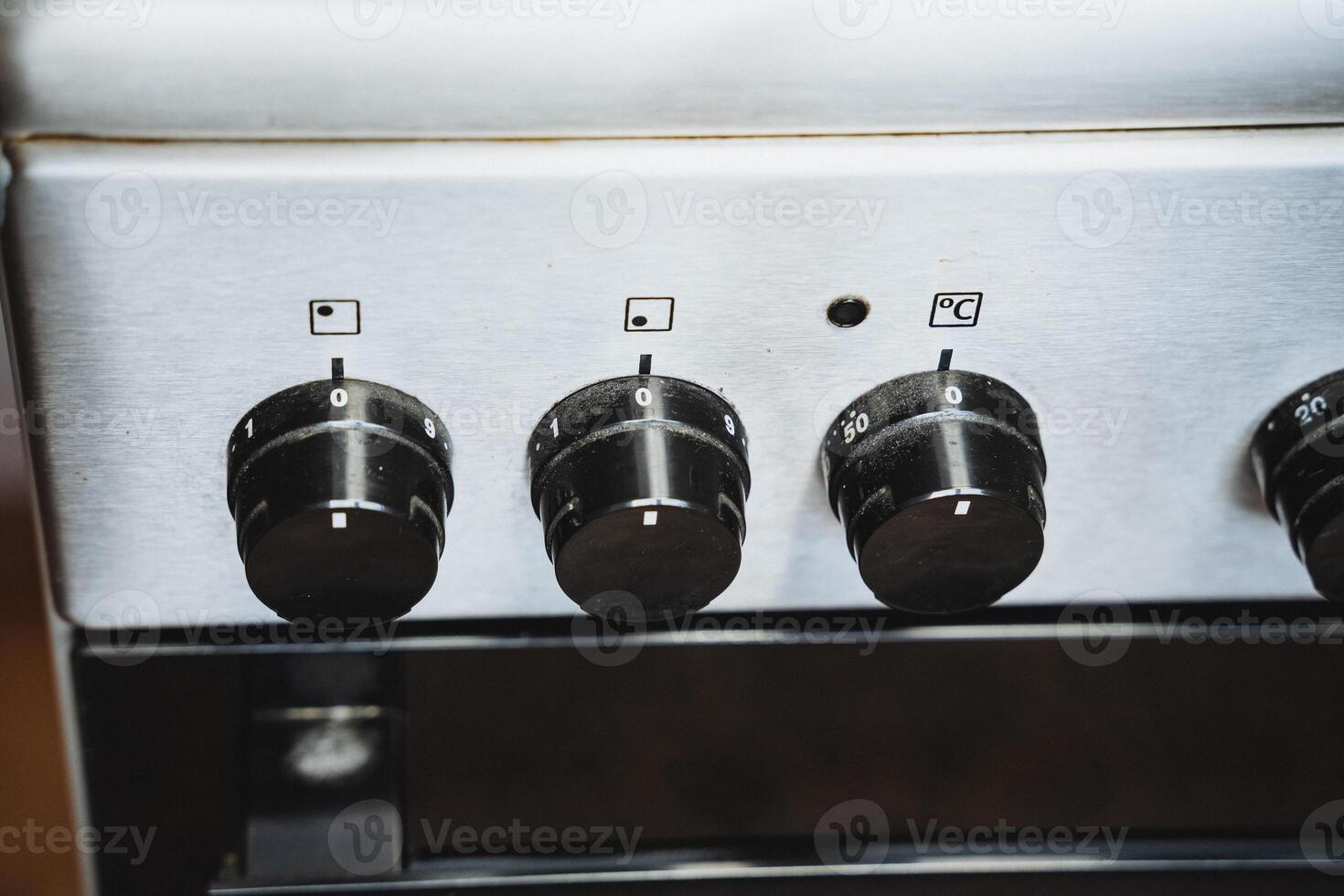 This image shows a closeup of a sleek, modern stove with four front knobs for efficient control over heating elements and cooking functions, enhancing your culinary experience photo