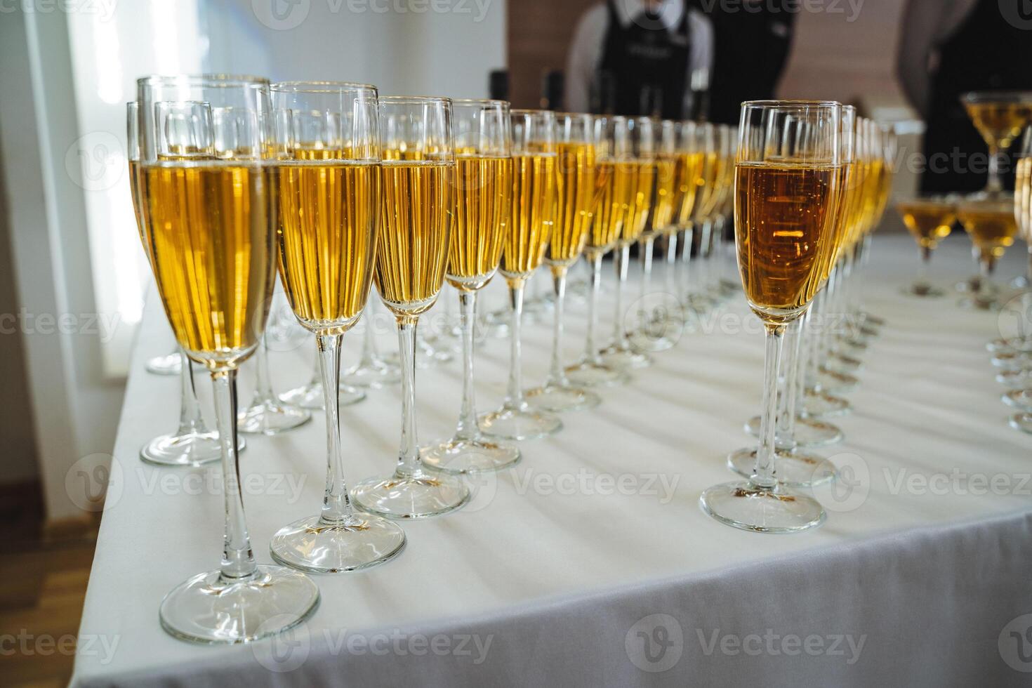 A beautiful row of sparkling champagne glasses is elegantly arranged on a polished table, ready to be filled with bubbly delight for a special celebration or gathering tonight photo