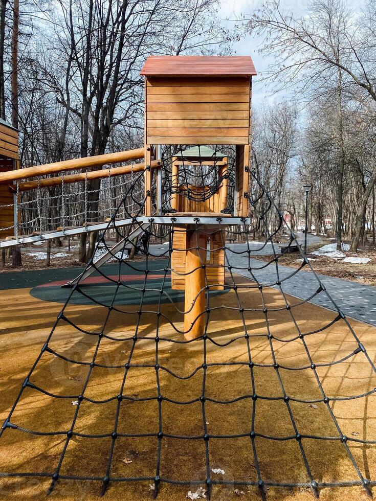 The Adventure Playground offers a challenging Climbing Net and a tall Wooden Tower in a serene park, ideal for outdoor fun, healthy exploration, and joyful play photo