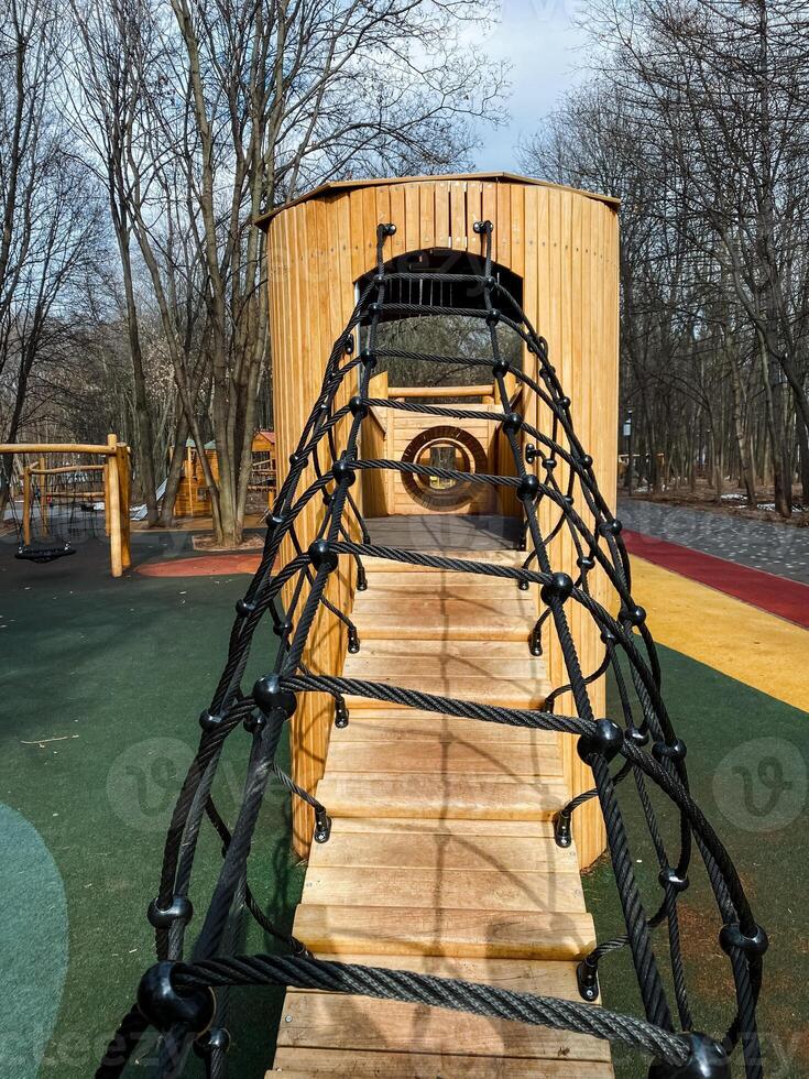 Discover a Unique Wooden Playground Structure featuring an exciting Rope Bridge and various Climbing Features, designed specifically for Children to enjoy Outdoor Fun photo
