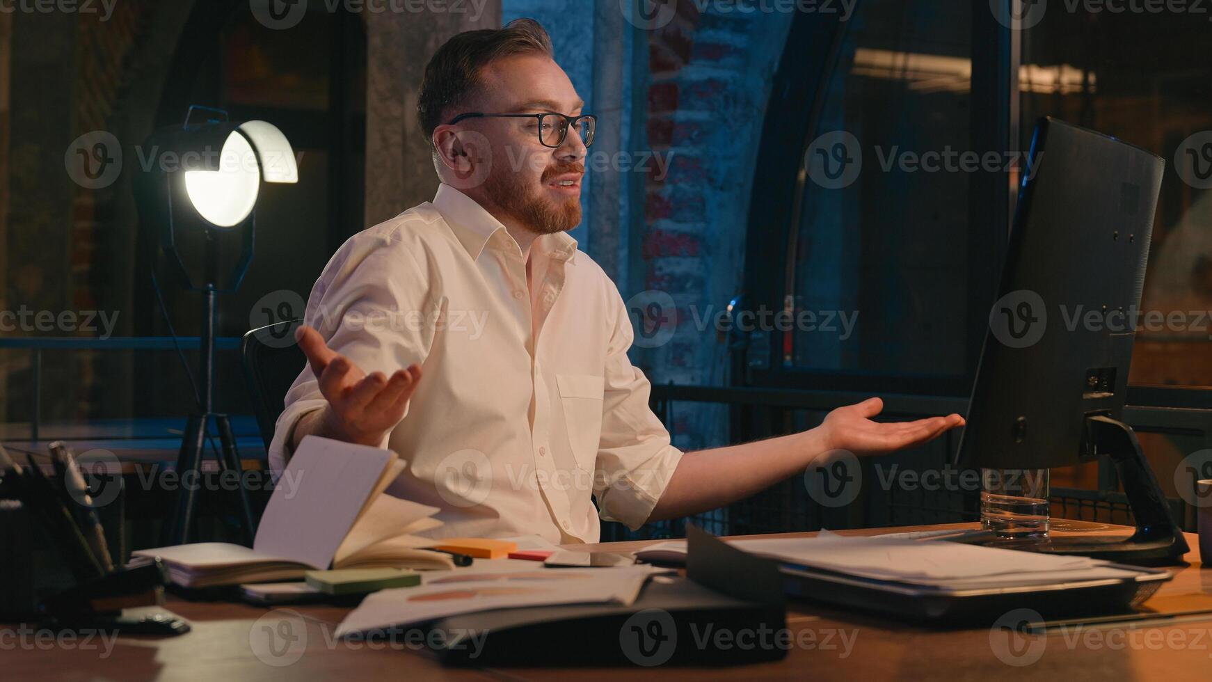 Caucasian man business guy businessman male in dark night evening office work smiling talking call conference talk negotiations online interview distant conversation consulting overtime chatting photo