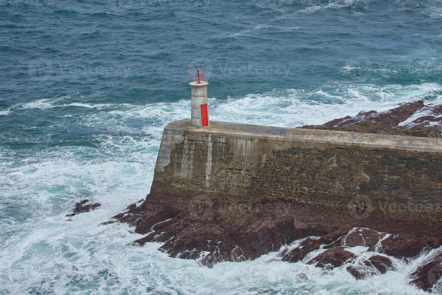 Viavelez lighthouse, asturias, spain, a beacon from above amidst the crashing waves photo