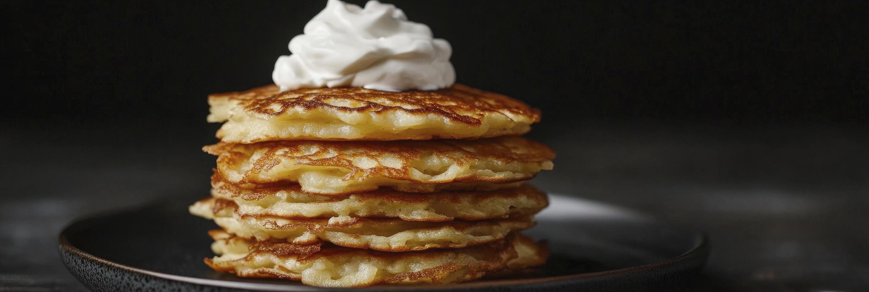 A stack of pancakes with whipped cream on top photo