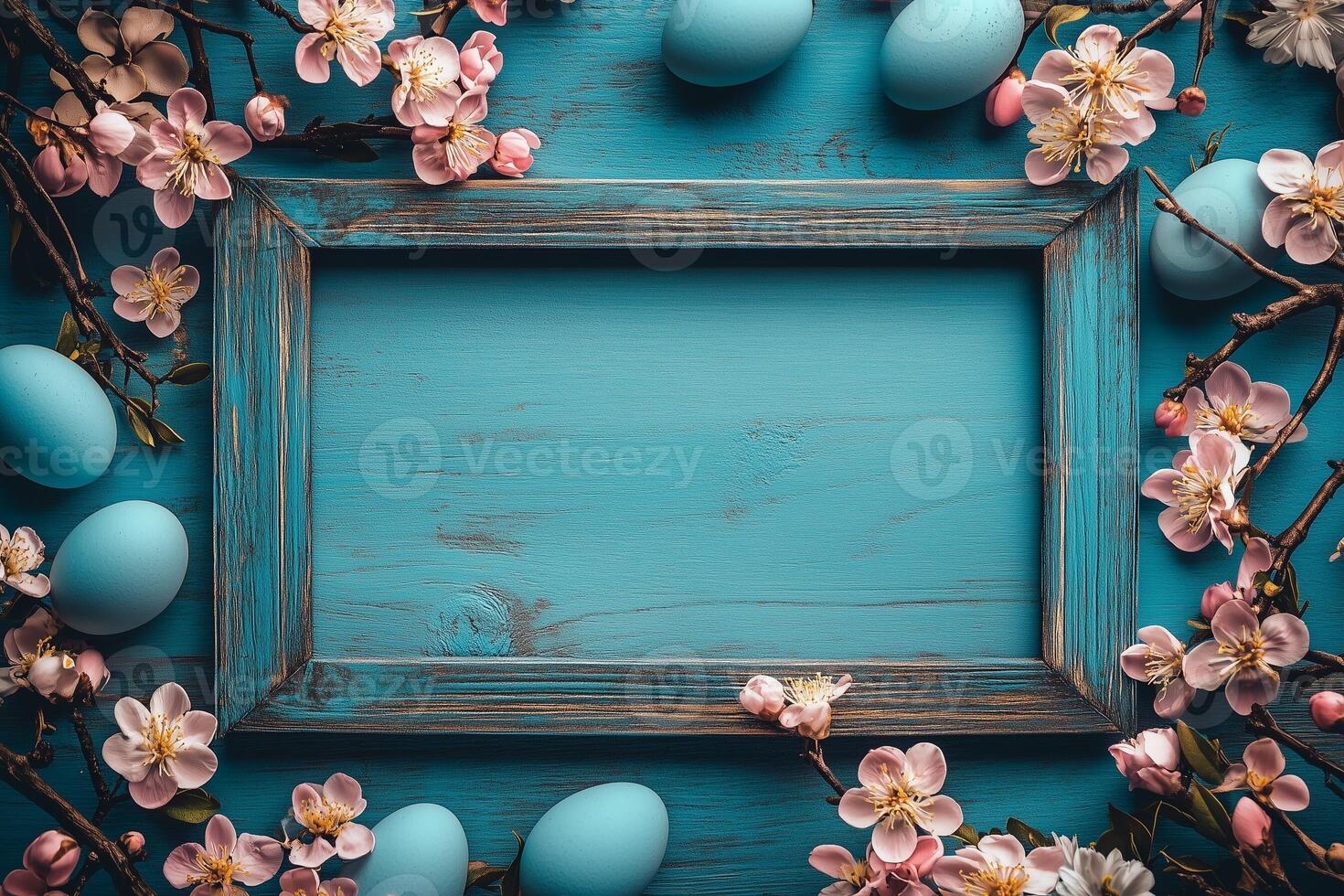 Vintage wooden frame surrounded by flowering branches and Easter eggs. photo