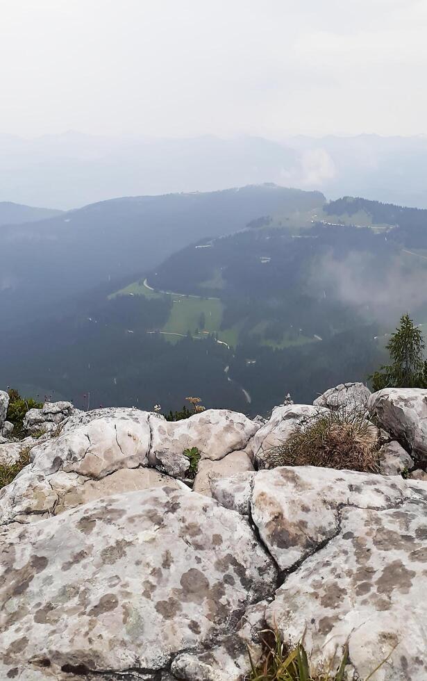 Fog. Rocky mountains illuminated by the bright summer sun, with a blue cloudless sky in the background. photo