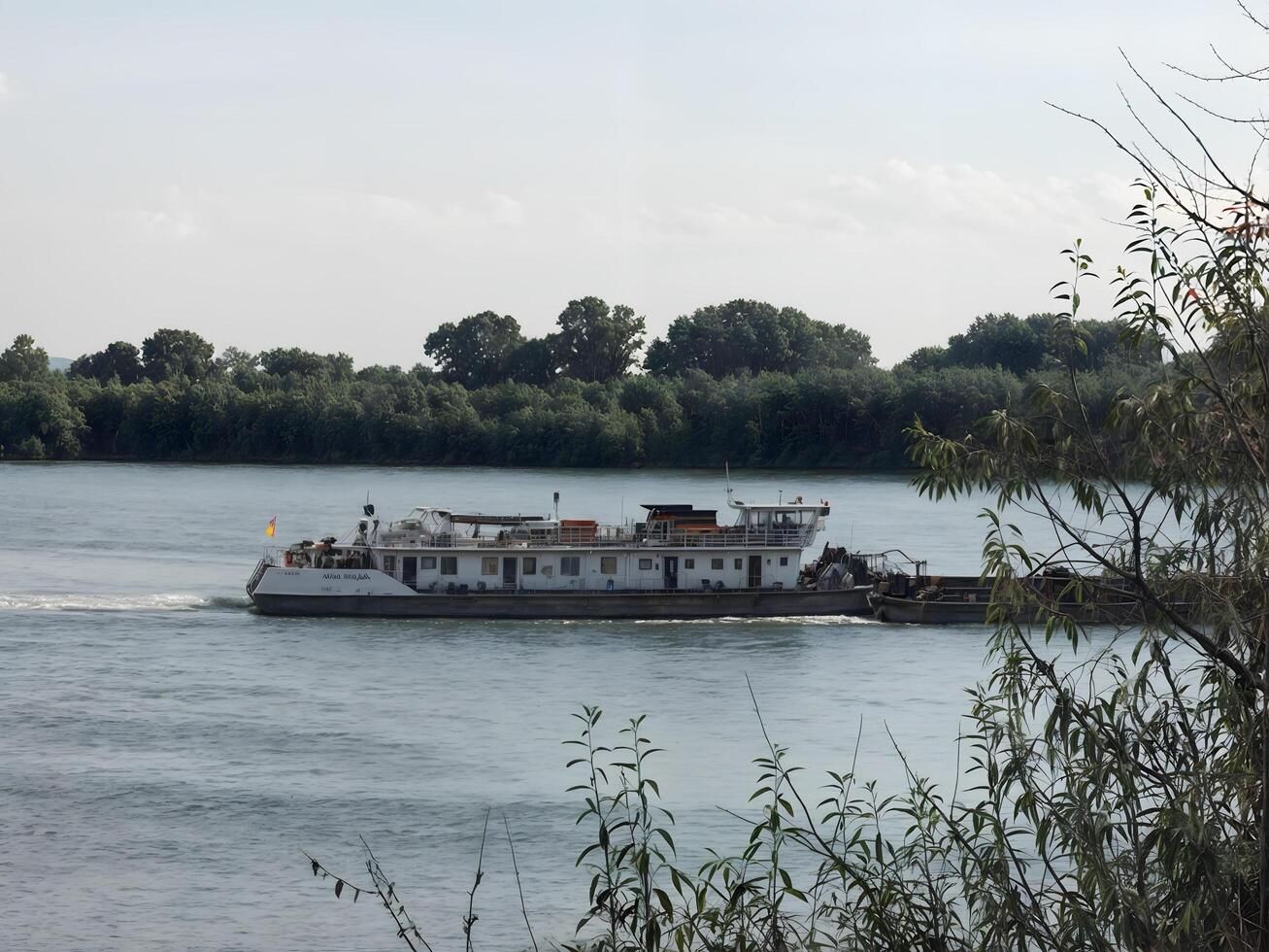 Water transport. A large cargo barge moves slowly along a calm river, reflecting in the water. photo